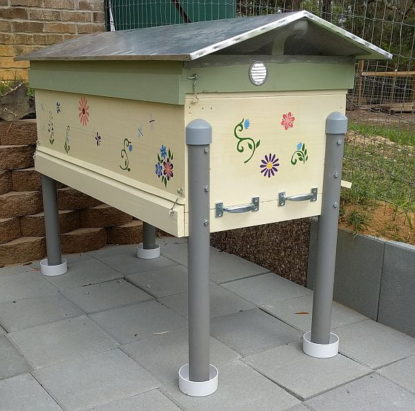 Refurbished hive installed in new bee yard "ditch" with ant traps ready to be filled with water.