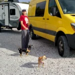 Sue with doggies beside van with RV in tow