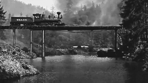 Old locomotive falling off burning bridge.
